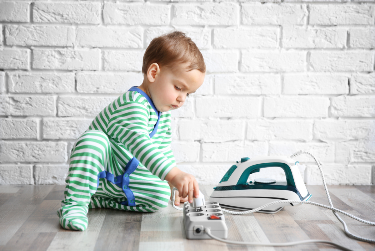 Small child playing with an electric plug resulting in an electrical hazard within the home